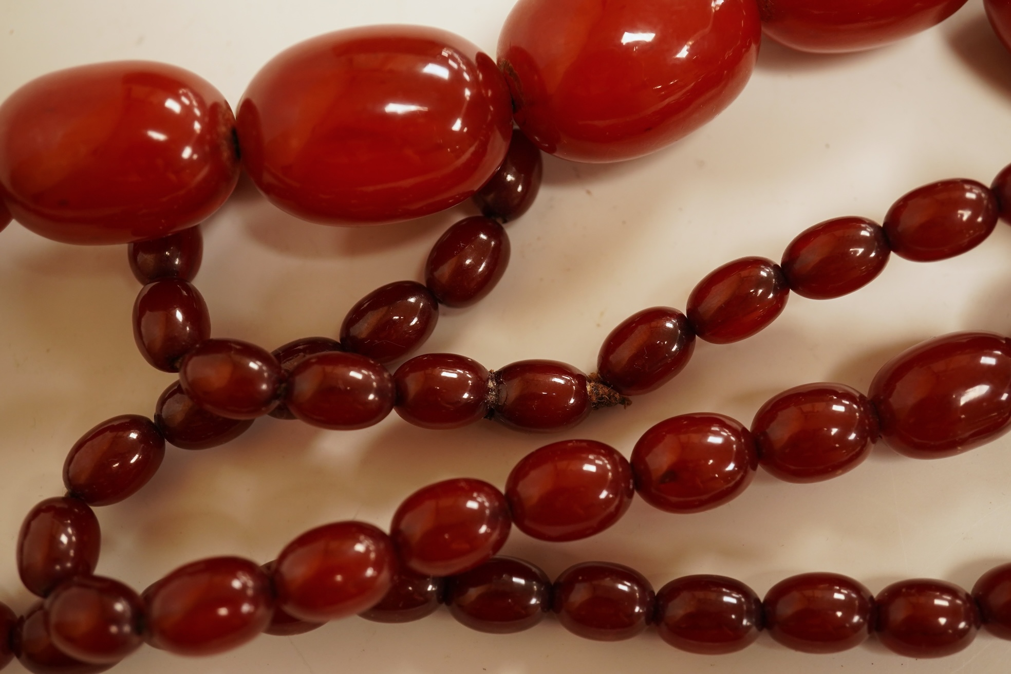A single strand graduated simulated cherry amber bead necklace, 76cm, gross weight 75 grams.